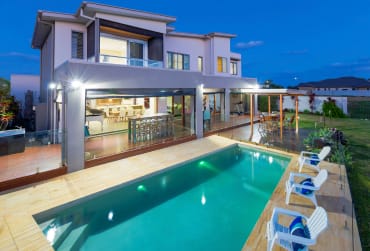 Serenity in the City: The Urban Farmhouse Retreat A picturesque urban farmhouse surrounded by lush greenery and vibrant plants, showcasing the harmonious blend of nature and modern living.